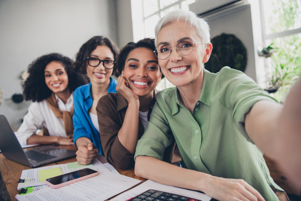 企业四位女性同事的照片，女权主义者社区领导团队建设会议，成功的愉快轻松办公室合作。图片下载
