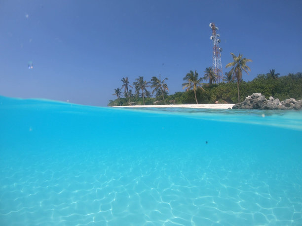 马尔代夫背景下的蓝绿色泻湖与海底的分割照片，远处是一座天堂般的岛屿。图片下载