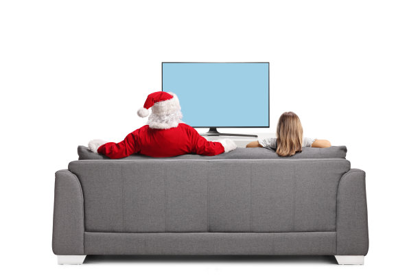 女孩和圣诞老人坐在沙发上看电视图片下载