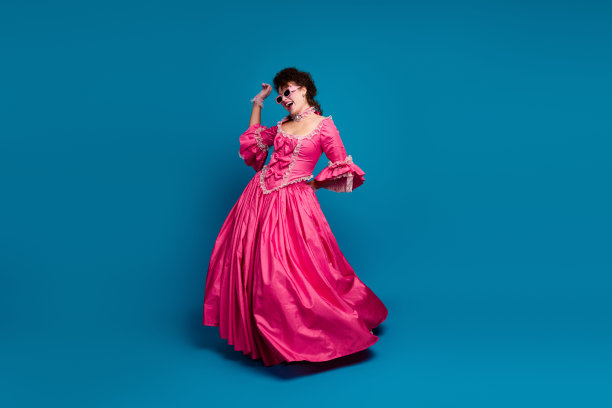 可爱的梦幻玛丽·安托瓦内特穿着紧身胸衣裙，在空旷的蓝色背景下玩得很开心的全身照片图片下载