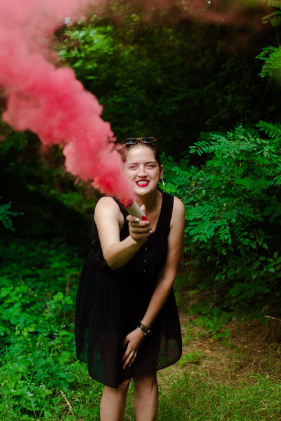 年轻女性与粉色烟雾玩乐的照片图片下载