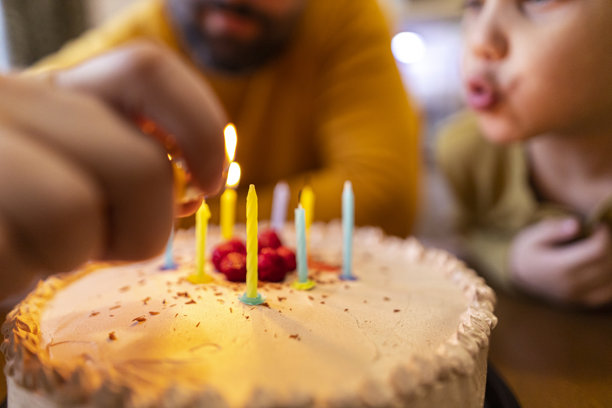 父亲和儿子，蜡烛点亮。通过胶卷摄影捕捉生日庆祝的温暖和怀旧。特写照片图片下载