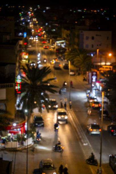 傍晚时分中央城市街道的照片，模糊的车灯和霓虹灯招牌。图片下载