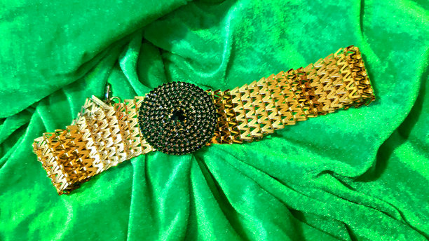 明亮绿色背景上的女性金饰。背景设计，摄影新颖。纺织品，面料模板，现代照片。图片下载