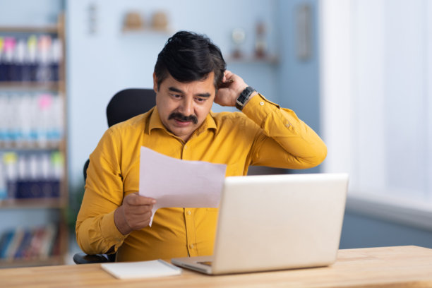 忧虑的商人在办公室坐着阅读分析文件的股票照片图片下载