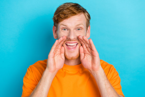 特写照片，时尚男士手臂靠近嘴巴，急切地说“快点，黑色星期五促销，低价衣物”，背景为青色。图片下载