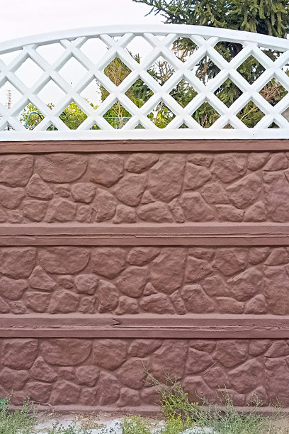 一面用棕色和白色油漆涂刷的混凝土围栏特写，竖版照片。图片下载