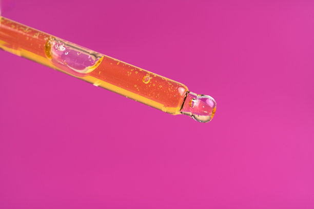 化妆品或精油的特写照片，玻璃滴管中滴落的精华液图片下载
