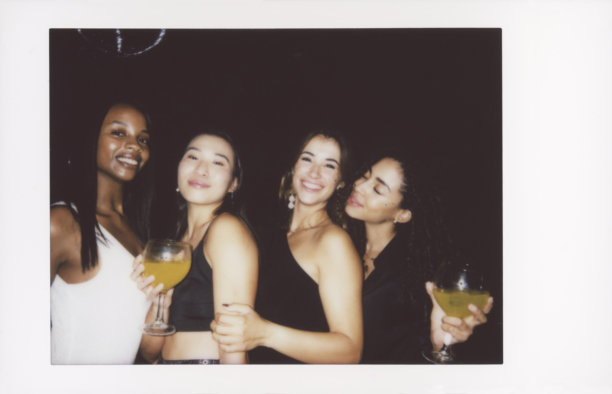 一群快乐的朋友在复古风格的照片中庆祝，手中举着鸡尾酒图片下载