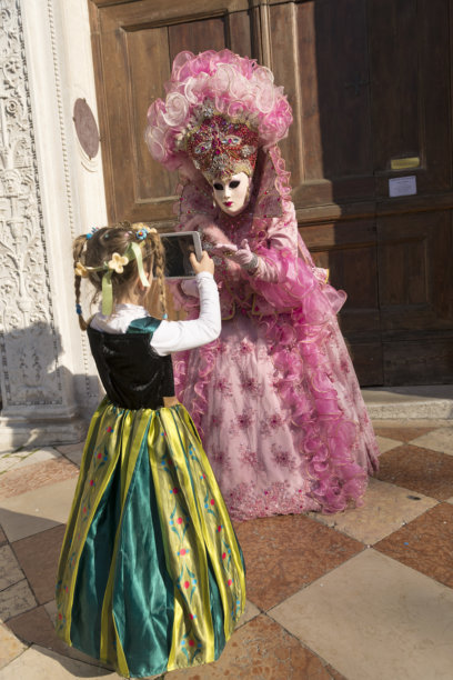 女孩在威尼斯圣扎卡里亚狂欢节上拍摄粉色面具的照片图片下载