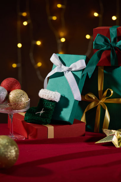 圣诞主题照片，正面视角，周围有许多物品，如五彩缤纷的礼品盒、圣诞闪烁球和装饰的小型LED灯。中央留有空白空间以便展示产品。图片下载