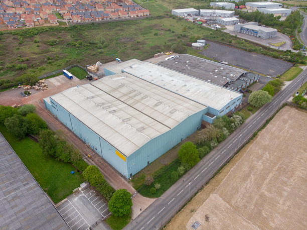 英国西约克郡韦克菲尔德镇一座大型废弃仓库或工厂建筑的航拍照片，展示了这座大型建筑及其周围的道路。图片下载