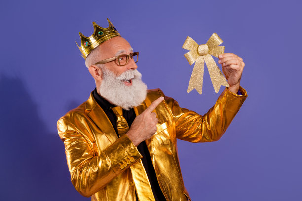 穿着时尚金色衣服的胡须绅士在紫色背景下试戴领结的照片肖像图片下载