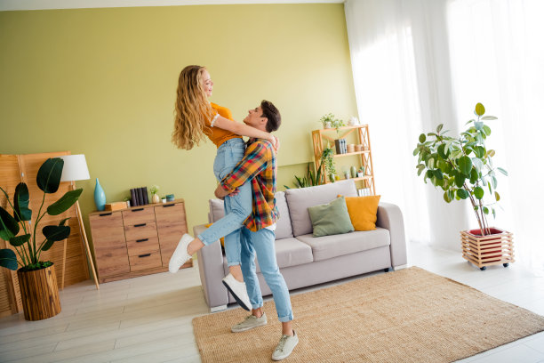 年轻情侣在宽敞的房子里度过春夏时光，男友抱着女友，充满浪漫气息的全身照片图片下载