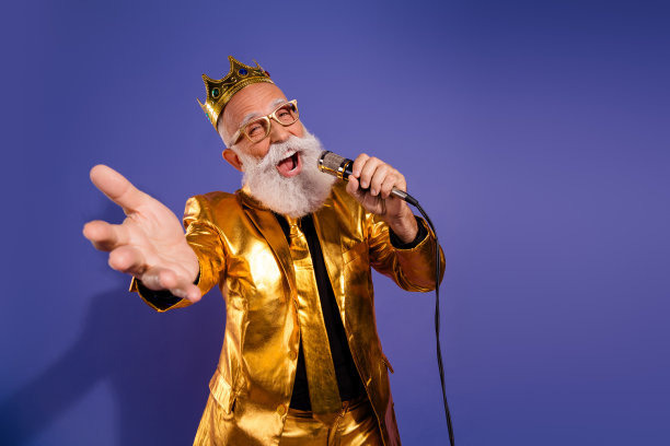 穿着华丽金色服装的老派男子在紫色背景下唱歌的照片肖像图片下载