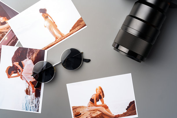 灰色桌子上的相机与五彩打印的照片图片下载
