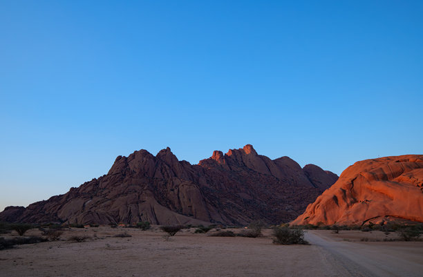 斯皮茨科普是位于纳米比亚纳米布沙漠中，乌萨科斯和斯瓦科普蒙德之间的一组光秃秃的花岗岩山峰或岛山，日落照片。图片下载