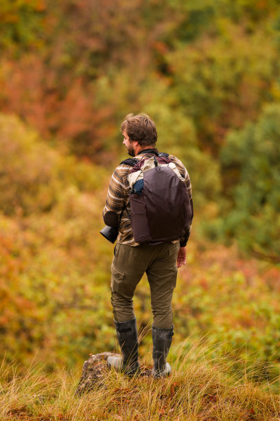 自然摄影师。年轻男性摄影师在秋季户外的肖像。背影。风景摄影师正在拍摄照片。图片下载
