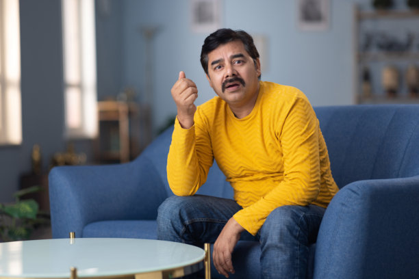 一个男人独自坐在家中，显得悲伤和沮丧的照片图片下载