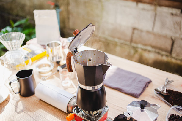 在温馨的厨房里，使用摩卡壶小心地在炉灶上冲泡咖啡，经典而美味的咖啡制作仪式。横向照片图片下载