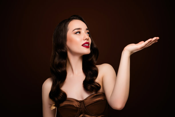 华丽富有的女明星在棕色背景上展示空白空间的新闻宣传照片图片下载