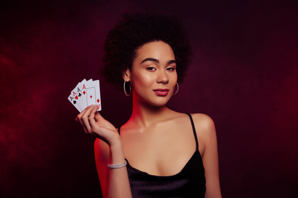 华丽富有的女性在深红色背景下玩扑克游戏的照片图片下载