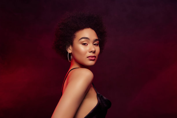 迷人华丽的模特在深红色背景下庆祝圣诞节的妆容和服装照片图片下载