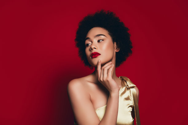 美丽模特触摸光滑肌肤的照片，背景为红色图片下载