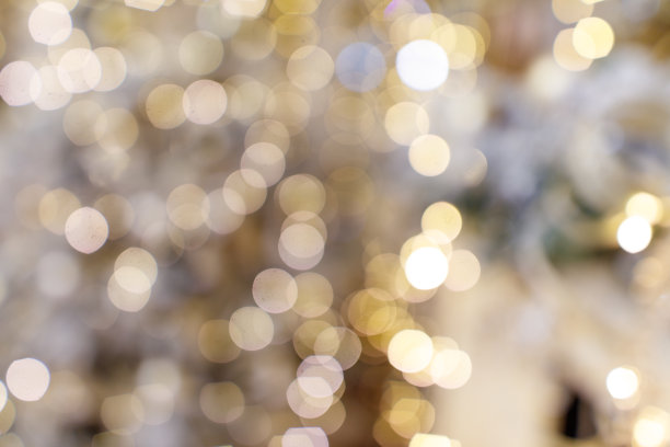 一张模糊的圣诞树图片，上面装饰着许多金色和白色的灯光。图片下载