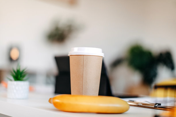 现代办公室桌子的照片，没有人，只有一杯咖啡和一根香蕉。图片下载