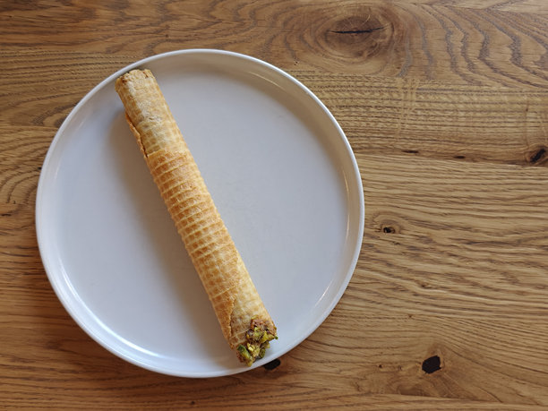 木桌上的饼干卷和炼乳的盘子。留有文字空间。适合甜品品牌或咖啡馆内容的照片。图片下载