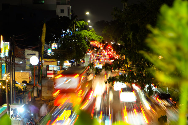 夜晚繁忙城市街道的长时间曝光照片，车流和交通灯交错。图片下载