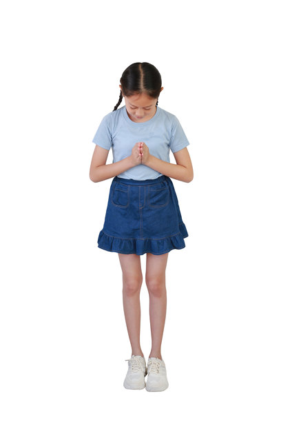 微笑的亚洲女孩穿着整洁的服装，做出尊敬或祈祷的手势，背景为白色摄影棚。全身照片带有抠图。图片下载