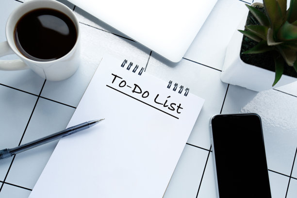 从上方拍摄的工作场所照片，包含笔记本电脑、笔、笔记本、植物和咖啡杯，留有空白空间。图片下载