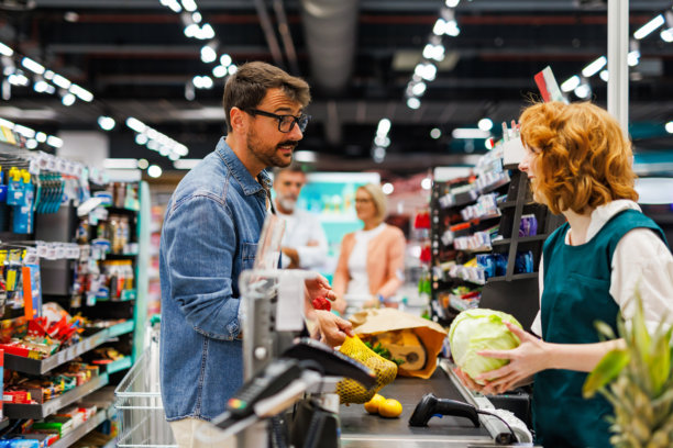 顾客在超市收银台付款购买杂货图片下载