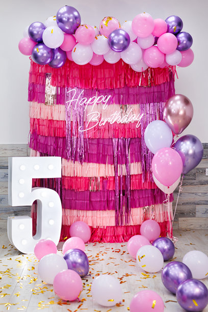 生日派对的亮丽照片区，装饰有流苏和气球，并配有霓虹灯标志。图片下载