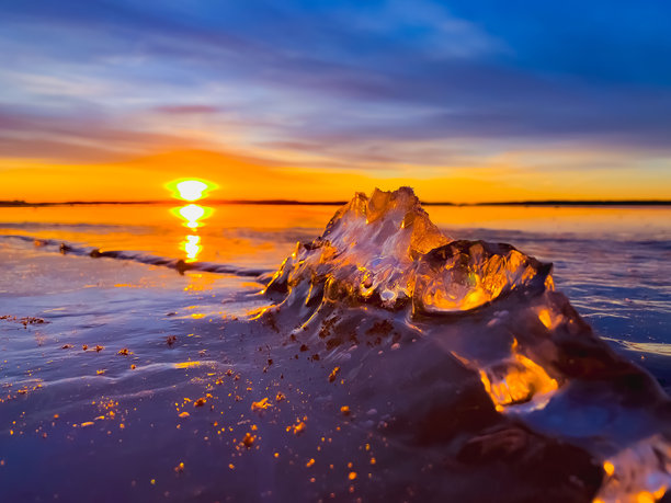寒冷的空气和冰冻的湖面在美丽的日落景观中。美丽的冰形状和阳光。照片来自芬兰索特卡莫。图片下载