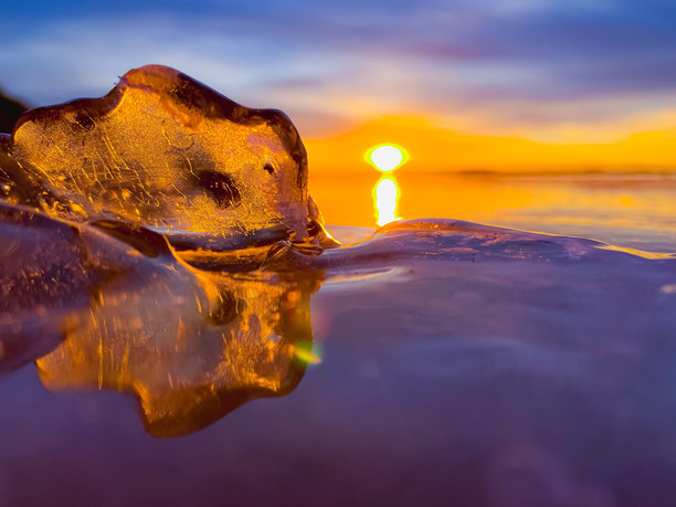 寒冷的空气和冰冻的湖面在美丽的日落景观中。美丽的冰形状和阳光。照片来自芬兰索特卡莫。图片下载