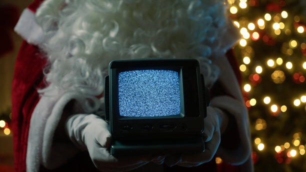 圣诞老人站在圣诞树前，手持静态电视信号图片下载