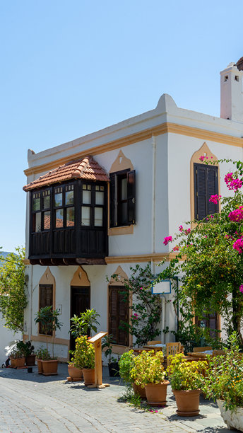 土耳其卡什的地中海风格房屋，木质阳台被绿色植物和九重葛环绕。漫步城市。竖版图片图片下载