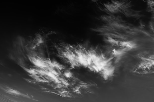 高白色卷云在天空中。黑白自然背景。戏剧性的云景。天气变化。风的质感。风的抽象。自下而上视角。高质量照片。图片下载