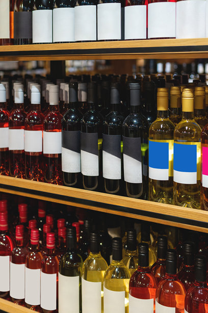 酒类商店货架上空标签的酒瓶特写垂直照片。图片下载