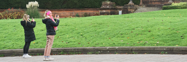 游客使用手机拍摄旅游目的地的照片图片下载