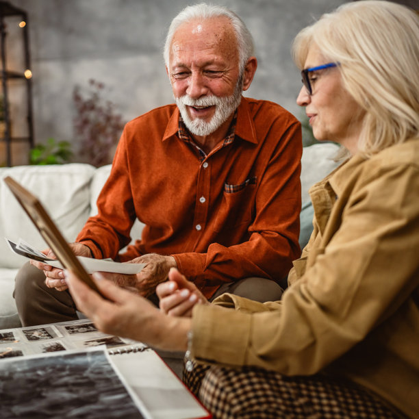 老年夫妇在客厅里观看家庭照片框。图片下载