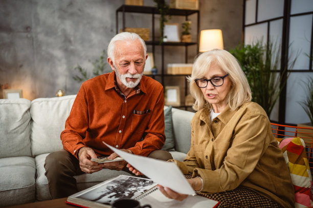 老年夫妇在客厅里翻看家庭照片册图片下载