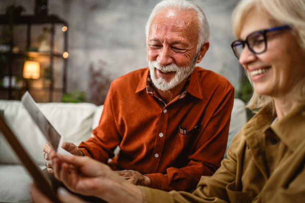老年夫妇在客厅里查看家庭照片相册图片下载