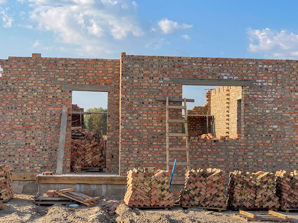 一面新砖墙的照片，展现了工匠的精湛技艺：美丽的缝隙和丰富的红砖色彩。图片下载