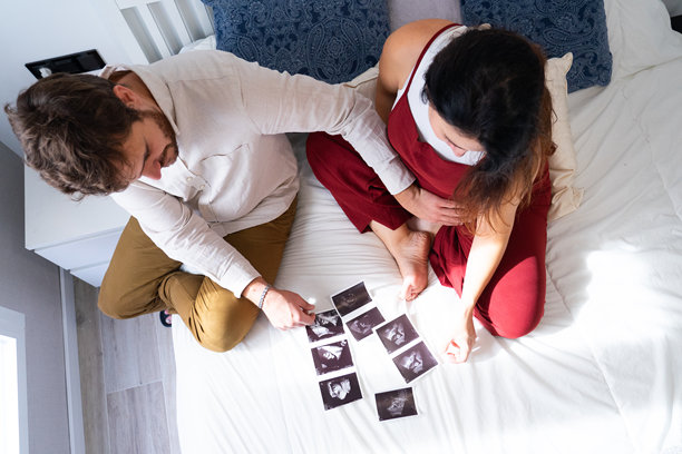 一对男女正在查看即将出生的宝宝的超声波照片图片下载
