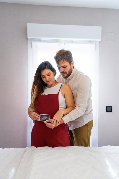 怀孕的夫妻在家中查看超声波照片图片下载