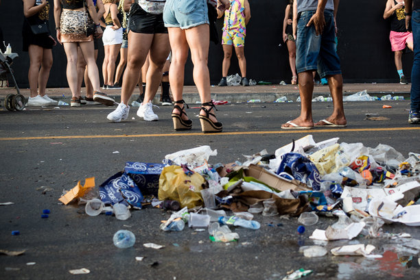 糟糕的照片，地上有垃圾，人们走过和站在附近。巴伊亚州萨尔瓦多的大型狂欢节活动。图片下载